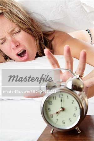 Woman waking up late and reaching for her alarm clock