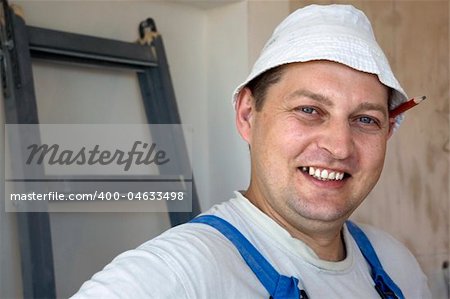 mature man worker wearing a uniform with a pencil behind his ear