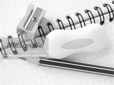 sharpener and pencils with eraser on the spiral notepad page