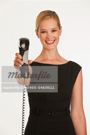 businesswoman holding up business phone with cord