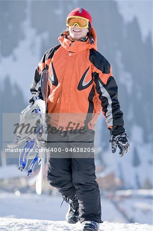 Lucky boy snowboarder in a mountain valley
