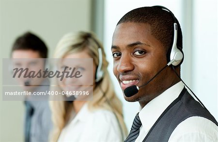 Businesspeople wearing headsets and smiling at work
