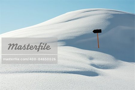 White, snowy landscape with a direction sign