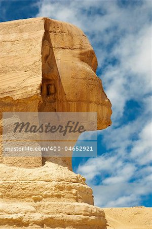 Side view of the Sphinx with blue skies and clouds in the background