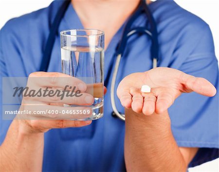 Close-up of a pill and a glass of water hold by a doctor