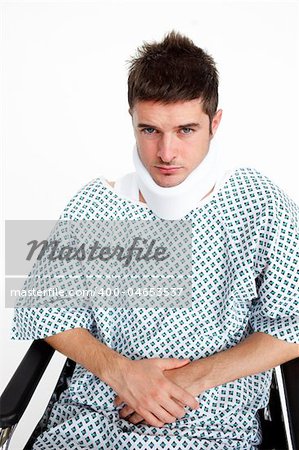 Man with a neck brace sitting in a wheelchair in hospital