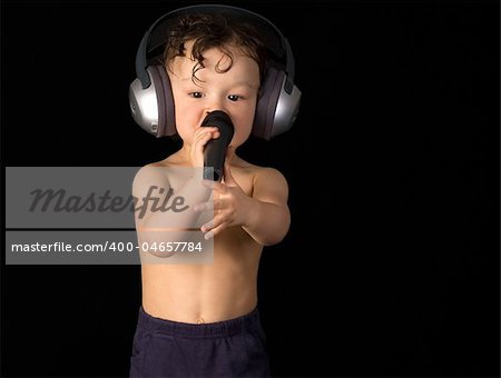 Sing baby with headphone and microphone, on a black background.