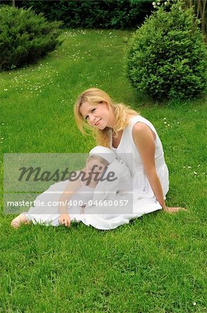 Young mother and daughter resting in meadow