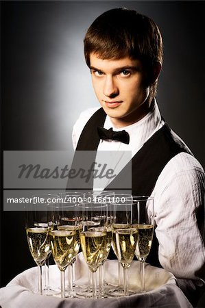 professional waiter in uniform is serving wine