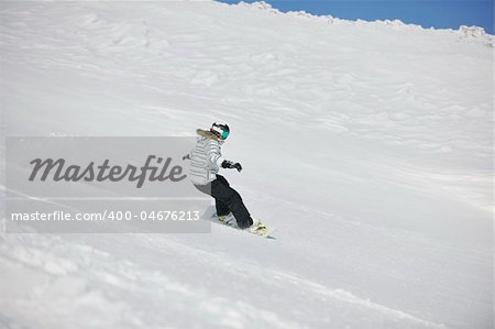 snowboard woman racing downhill slope and freeride on powder snow at winter season and sunny day