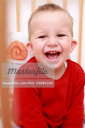 Portrait of cute newborn laughing  in crib