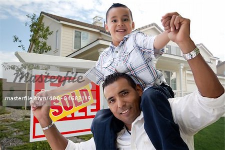 Hispanic Father and Son in Front of Their New Home with Sold Home For Sale Real Estate Sign.