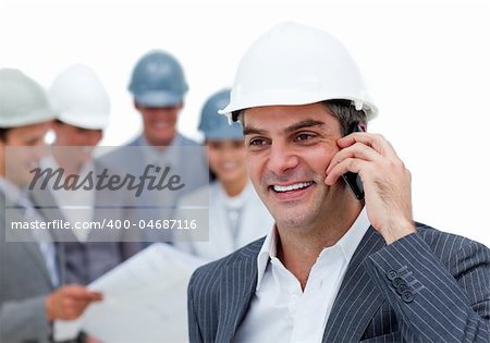 Mature male architect on phone standing in front of his team