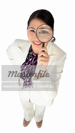 Confident businesswoman holding a magnifying glass isolated on a white background
