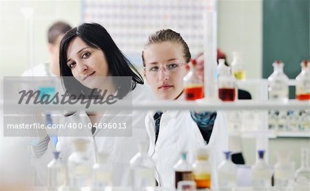 young woman students group in bright chemistry  lab