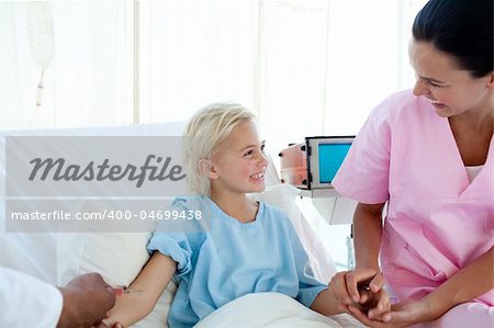 Young nurse smiling to a little girl who receiving an injection in a hospital Young nurse smiling to a little girl who receiving an injection in a hospital
