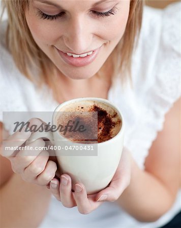 Delighted woman drinking a coffee at home
