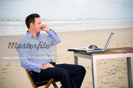 Business man with office on the beach