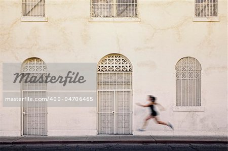 Woman runs past interesting white and tan building
