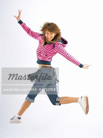 Dancing woman with brown long hair and happy smiling facial expression jumping up.