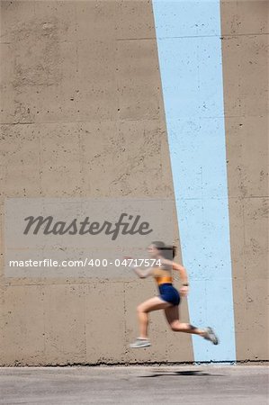 Woman sprinter practices her dash to the finish line.