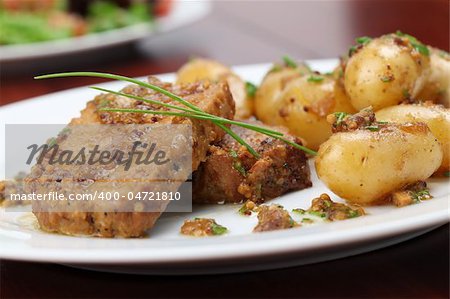 Roast pork on onion and mustard with baby potatoes