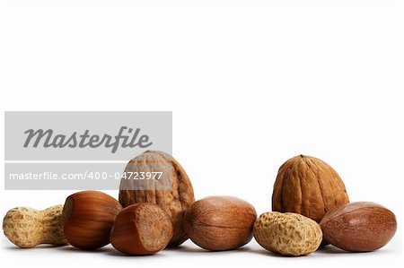 two of each pecan hazelnuts walnuts and peanuts on white background