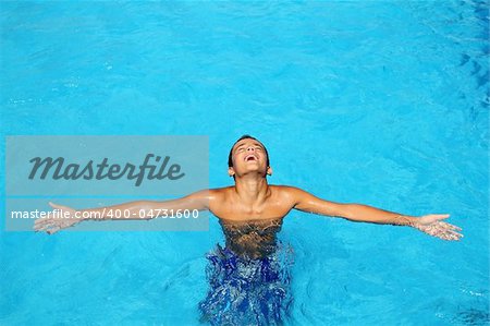 boy teenage relaxed open arms blue swimming pool summer vacations