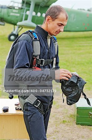 Portrait of the parachutist in overalls against the plane