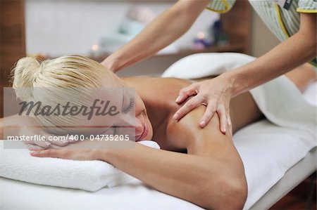 beautiful young woman at spa and wellness back massage treatment