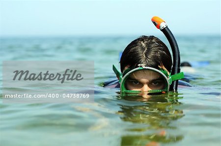 The young guy plunges under water with swimming equipment. Diving.