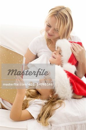 Woman and kids reading a tale at christmas time laying on the sofa