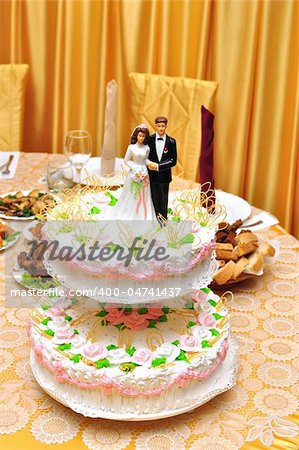 statues on top of wedding cake on the holiday table