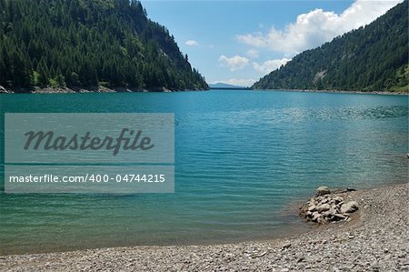 summer panoramic view of alpine lake, Agaro artificial lake, Italy