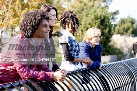 A group of friends outside in a park having fun - shallow depth of field with sharp focus on first person