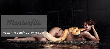 Beautiful woman lying with Python in water