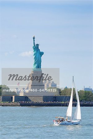 Statue of Liberty as American landmark in New York City Manhattan over Hudson River with sailing boat