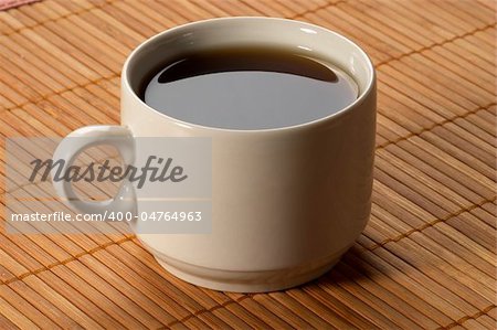 Little white espresso coffee cup on a bamboo mat (upprer view)