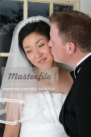 Beautiful Asian and Causian bridal couple on their wedding day