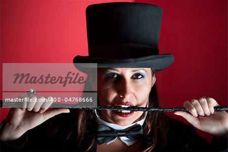 Woman dressed like a circus ringmaster with whip