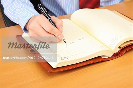 Businessman writing a note at his workplace.