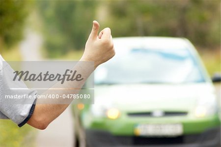 Man hitching green car on road
