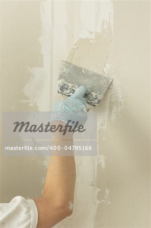 Woman hand with palette knife glazing wall