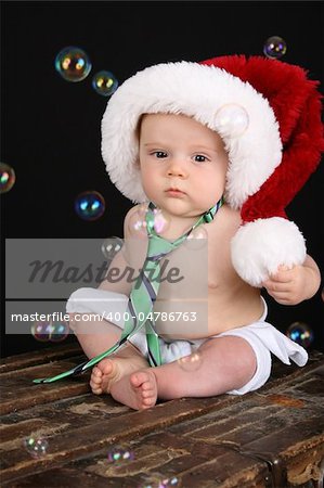 Cute christmas baby boy sitting on an antique trunk