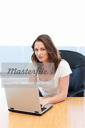 Portrait of a businesswoman working on laptop at a table in the office