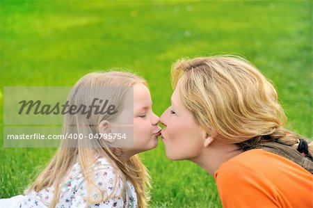 Mother is kissing her daughter