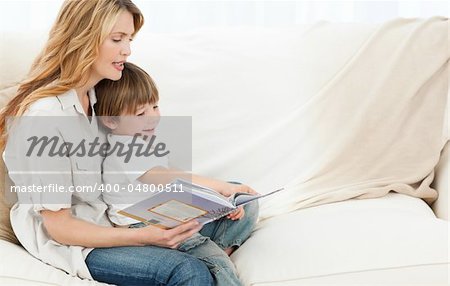 Mother reading with her son on the sofa
