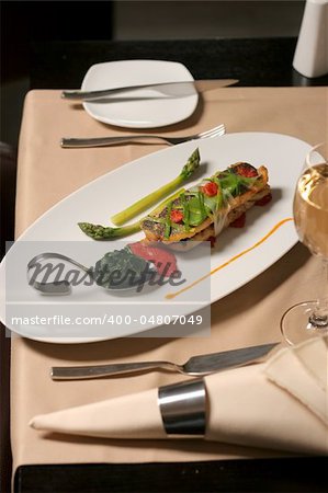 restaurant table with fish asparagus and spinach plate