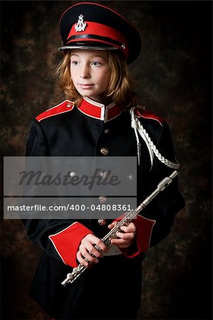 portrait of a twelve year old girl wearing her marching band uniform holding her flute low-key studio shot