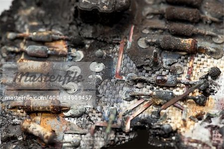 A close-up image of burnt components of a circuit board.